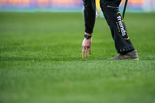 Ground staff inspects the pitch