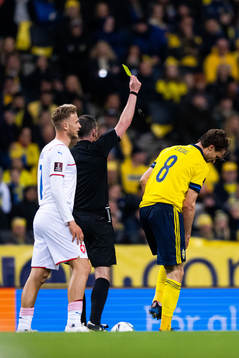 Albin Ekdal of Sweden receives a yellow card from referee