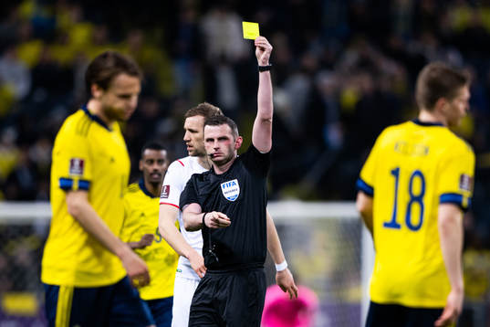 Joakim Nilsson of Sweden receives a yellow card from