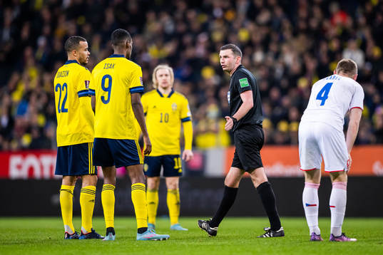 Robin Quaison and Alexander Isak of Sweden talk to referee