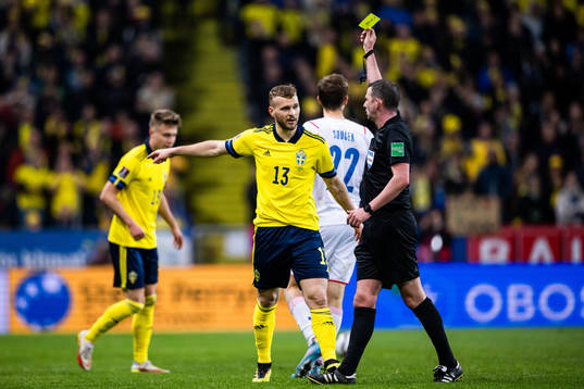 Jesper Karlström of Sweden receives a yellow card from