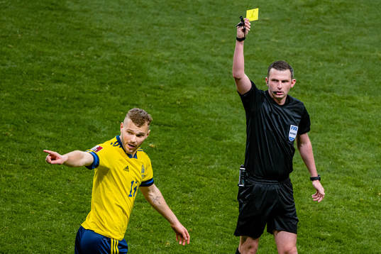 Jesper Karlström of Sweden receives a yellow card from