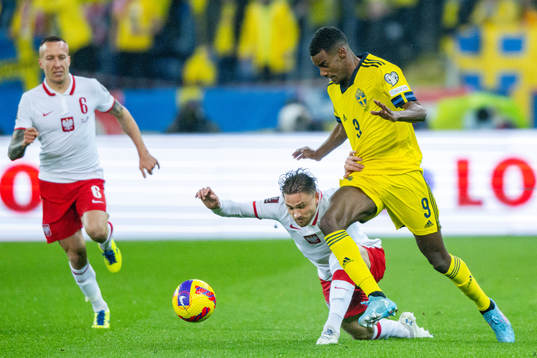 Matty Cash of Poland and Alexander Isak of Sweden