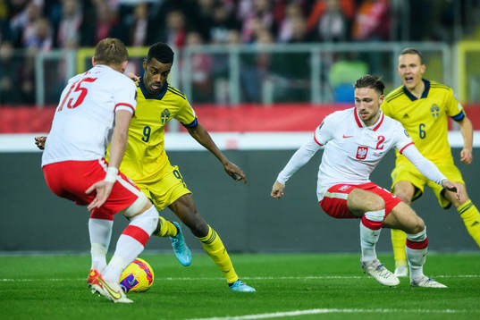 Alexander Isak of Sweden against Kamil Glik and Matty Cash