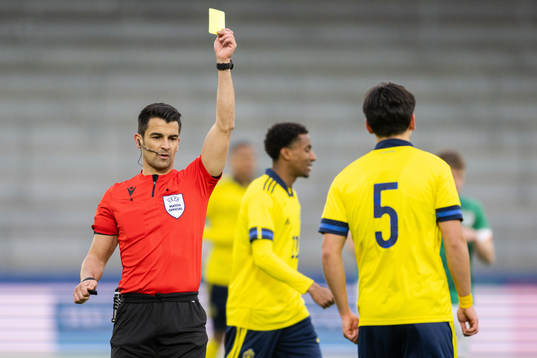 Eric Kahl of Sweden receives a yellow card from referee