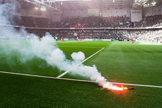 En bengal ligger och brinner på konstgräset