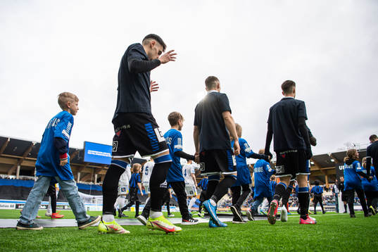 Sirius spelare gör entré till fotbollsmatchen i
