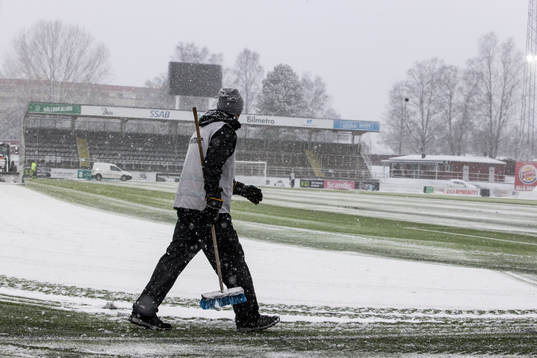 Funktionär sopar planen innan fotbollsmatchen i Superettan