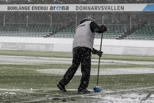 Funktionär sopar planen innan fotbollsmatchen i Superettan