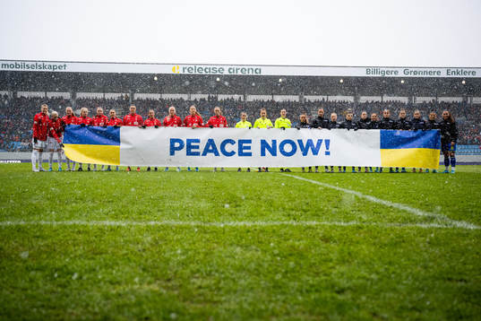 The players hold a «Peace Now!» sign