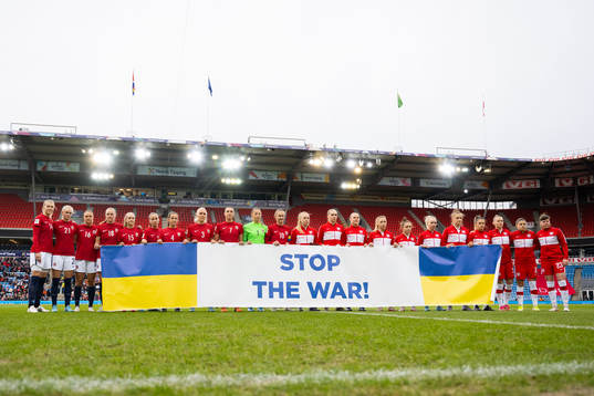Players of Norway and Poland with a "Stop the War!" banner
