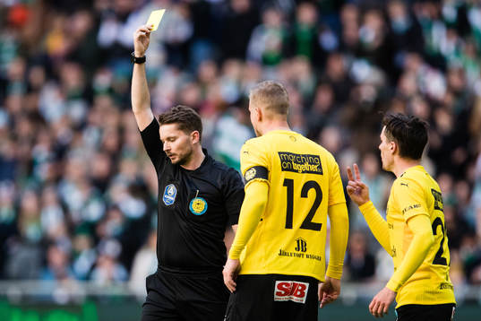 Domare Joakim Östling ger ett gult kort till Mjällbys