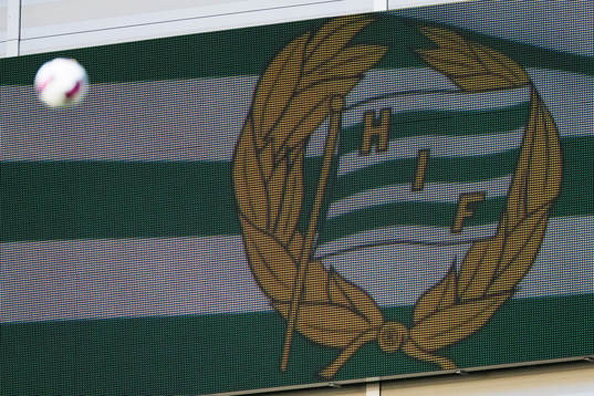 En fotboll flyger förbi en storbildsskärm med Hammarbys