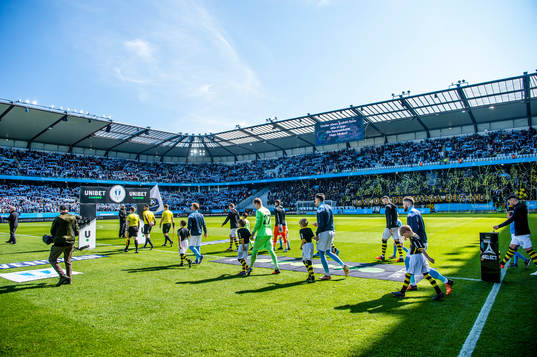 Spelarna kommer in på arenan innan fotbollsmatchen i