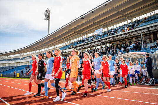 Spelarna gör entré till fotbollsmatchen i damernas
