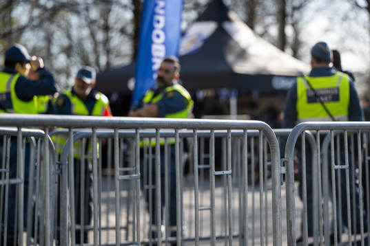Vakter syns bakom ett kravallstaket vid entrén