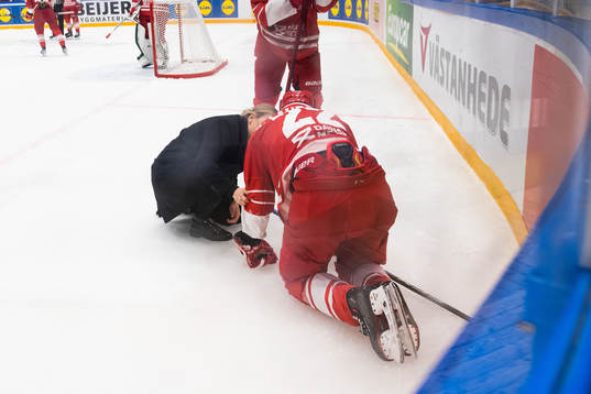 Markus Lauridsen of Denmark receives medical attention
