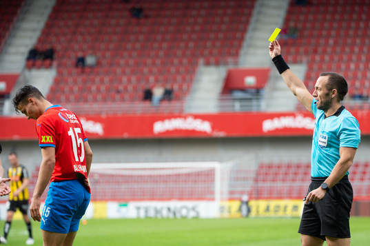 Domare Kaspar Sjöberg delar ut ett gult kort till