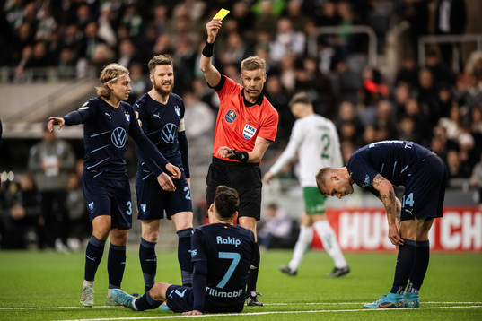 domare Glenn Nyberg delar ut ett gult kort till Malmö FFs