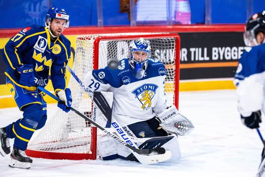 Oskar Lang of Sweden  and goalkeeper Harri Säteri of