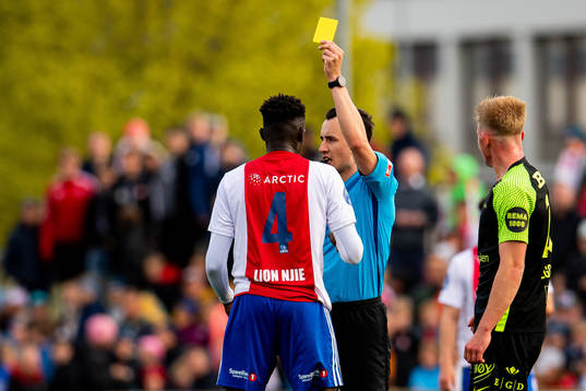 Momodou Lion Njie of KFUM is shown a yellow card by Mischa