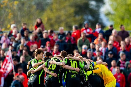 Felix Horn Myhre and players of Brann gather in a circle