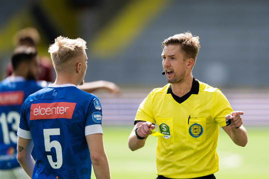 Domare Fredrik Hansson diskuterar med Norrbys Johan