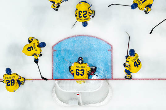 The players of Sweden gather around goaltender Marcus