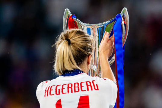 Ada Hegerberg of Lyon walks past the winners trophy