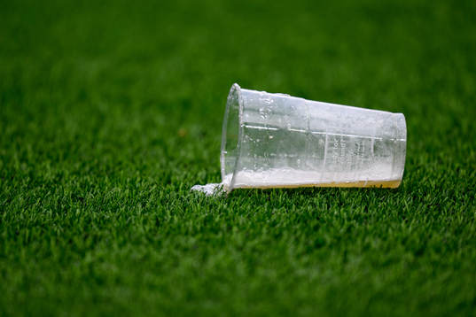 Ett inkastat plastglas på planen