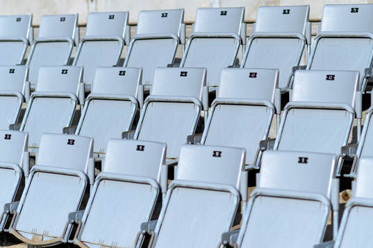 Tomma stolar på läktaren före fotbollsmatchen i