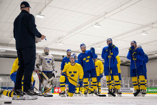Assistant coach Markus Åkerblom in front of players of