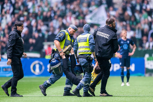 Vakter bär ut en planstormare