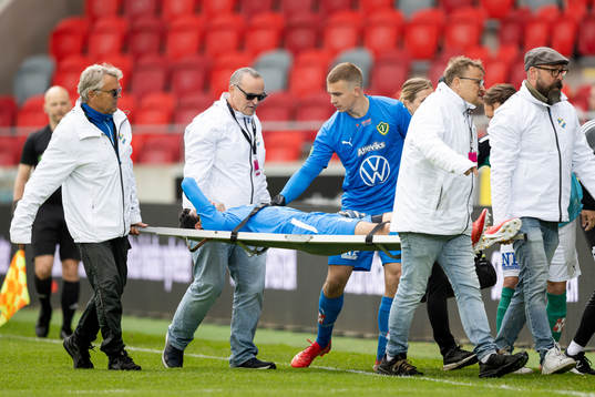 Jönköpings målvakt Tom Amos lämnar planen på bår