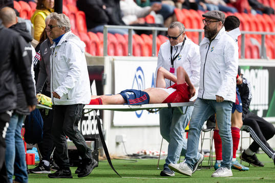 Östers Adam Bergmark Wiberg lämnar planen på en bår