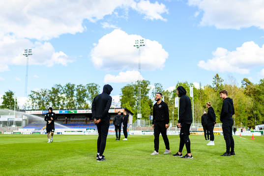 Hammarbys spelare inspekterar planen före fotbollsmatchen