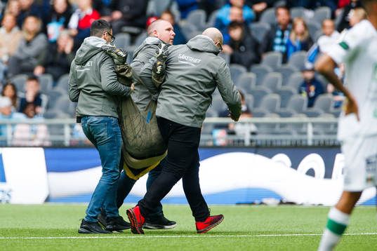 Vakter bär ut en supporter från plan
