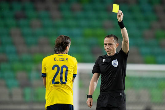 Kristoffer Olsson of Sweden receives a yellow card from