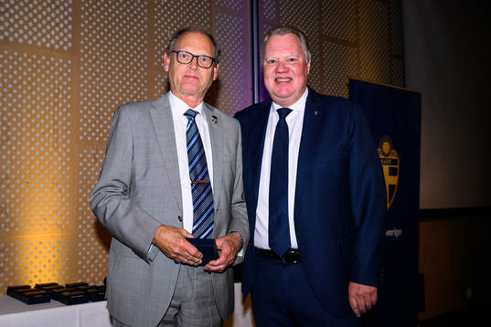 Stefan Fridlund tar emot ett förtjänsttecken i guld