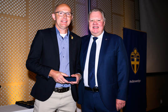 Peter Junhem tar emot ett förtjänsttecken i guld