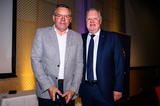 Thorbjörn Skalare tar emot ett förtjänsttecken i guld