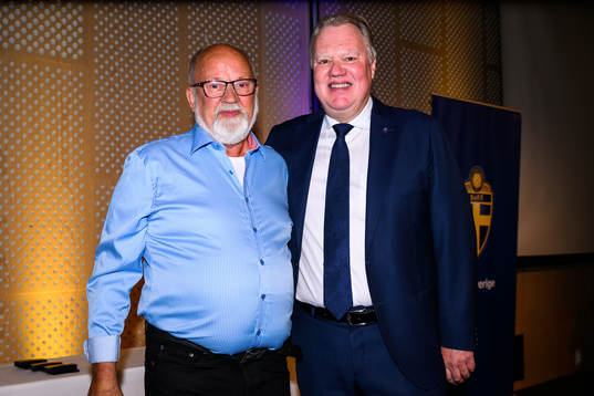 Leig Thell tar emot ett förtjänsttecken i guld