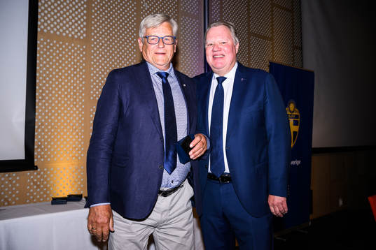 Bonny Karlsson tar emot ett förtjänsttecken i guld
