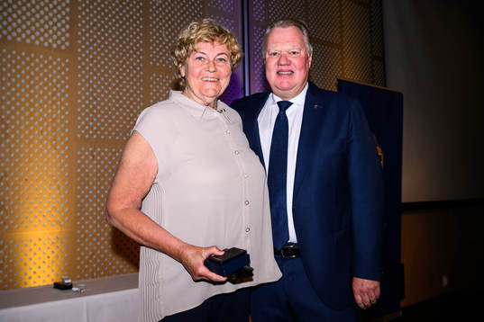 Monika Zentio tar emot ett förtjänsttecken i guld