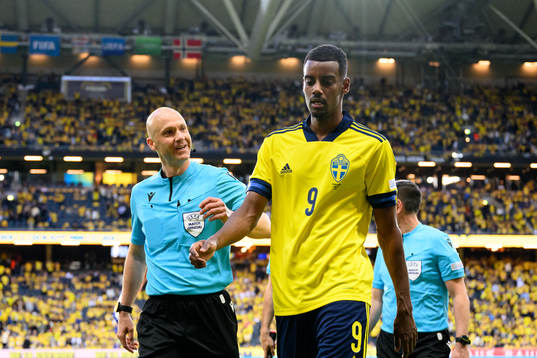 Referee Anthony Taylor and Alexander Isak of Sweden