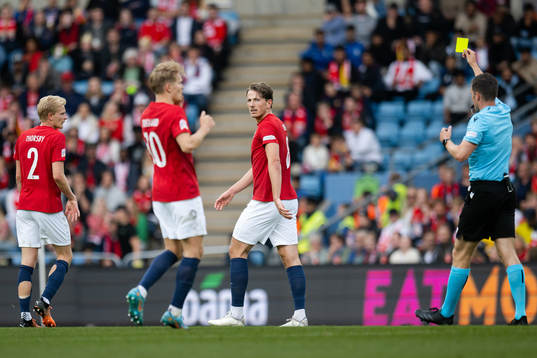 Sander Berge of Norway receives a yellow card