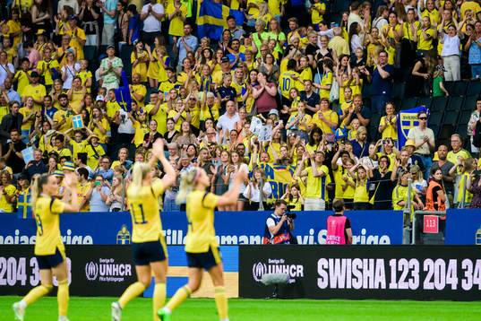 Swedish supporters celebrate with the players of Sweden