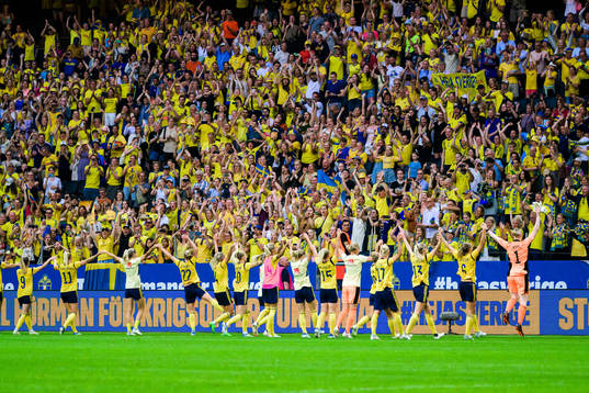Swedish supporters celebrate with the players of Sweden