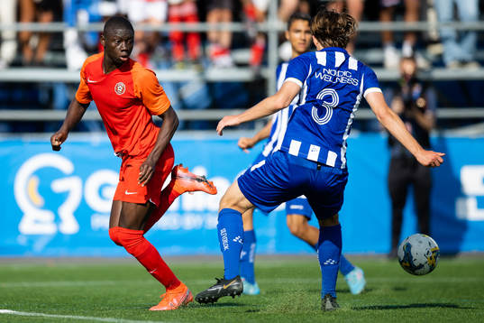 En spelare i Right to Dream klackar bollen förbi en IFK