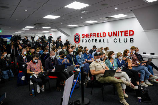 Member of the press follow a press conference with the